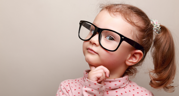 A child with glasses making a contemplative expression